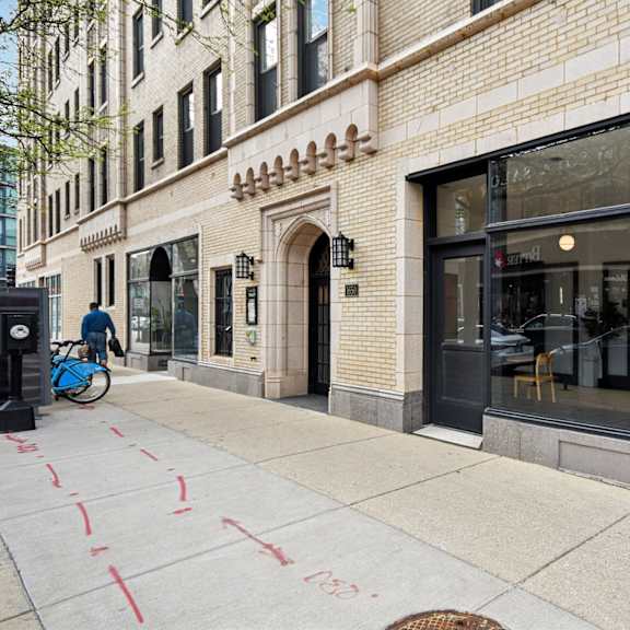 a street view of a building with a bicycle parked on the sidewalk.