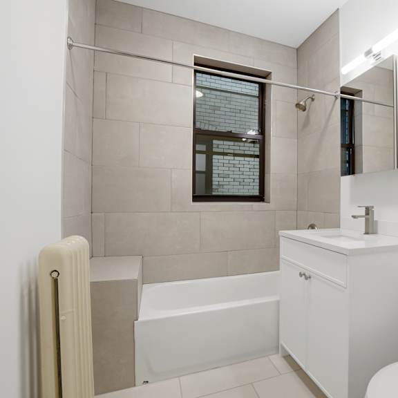 a white bathroom with a tub, toilet, and sink.