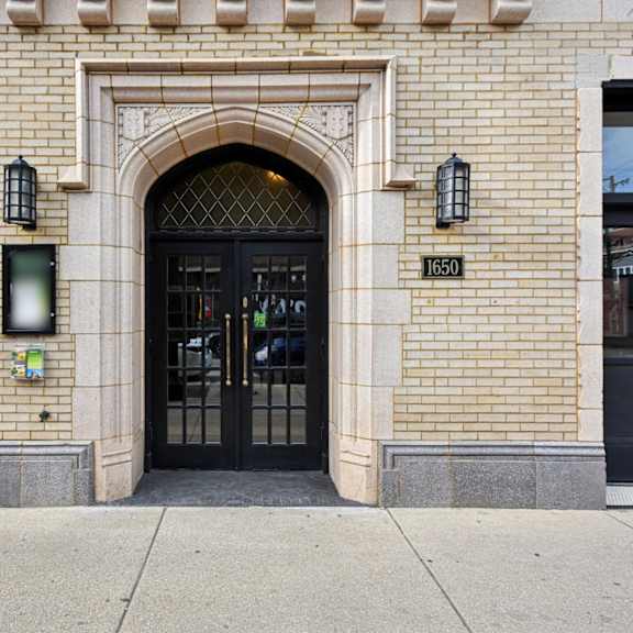 a building with a black door and windows with black bars.
