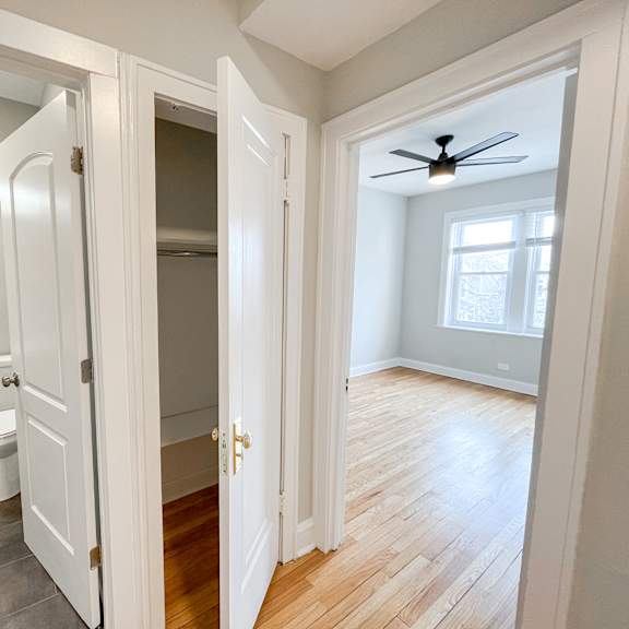 an open doorway into a bathroom with a toilet and a closet