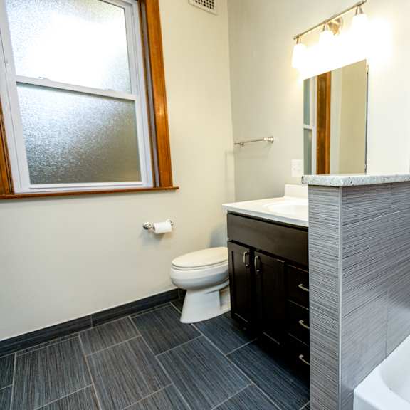 a bathroom with a toilet, sink, and tub.