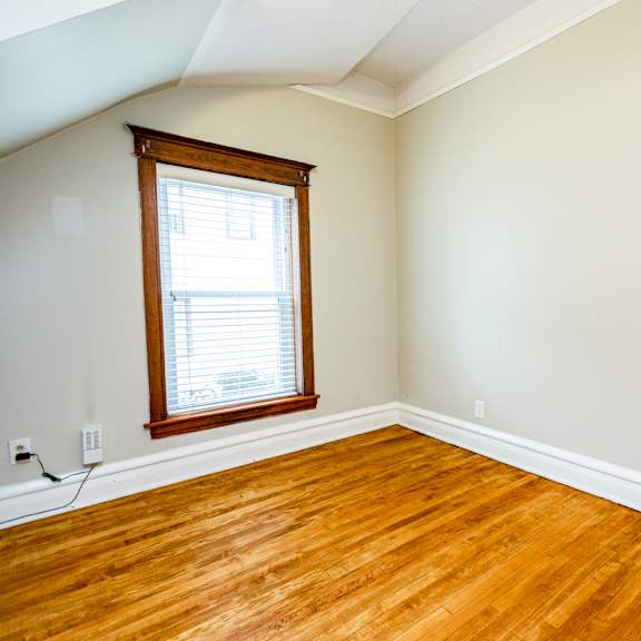 a room with a window and wooden floors.