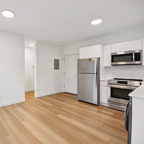 a kitchen with a refrigerator, oven, and microwave.