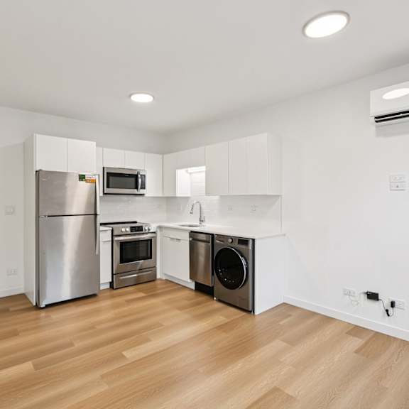 a kitchen with wooden floors and white walls.