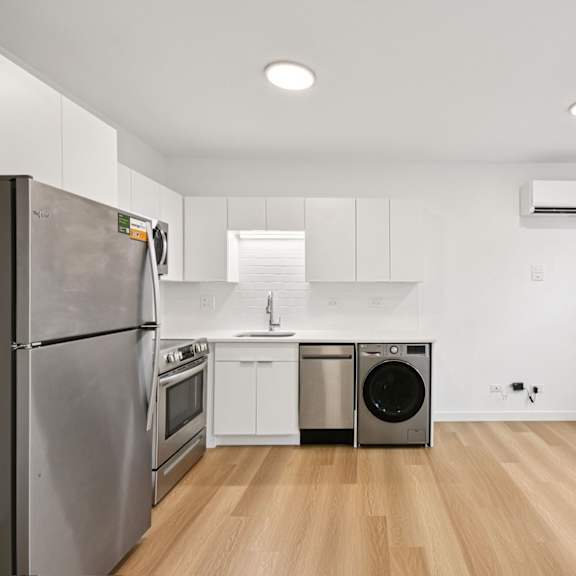 a modern kitchen with wooden floors and stainless steel appliances.
