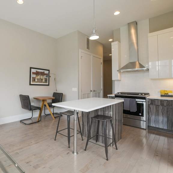 a kitchen and dining room with a white table and a tv