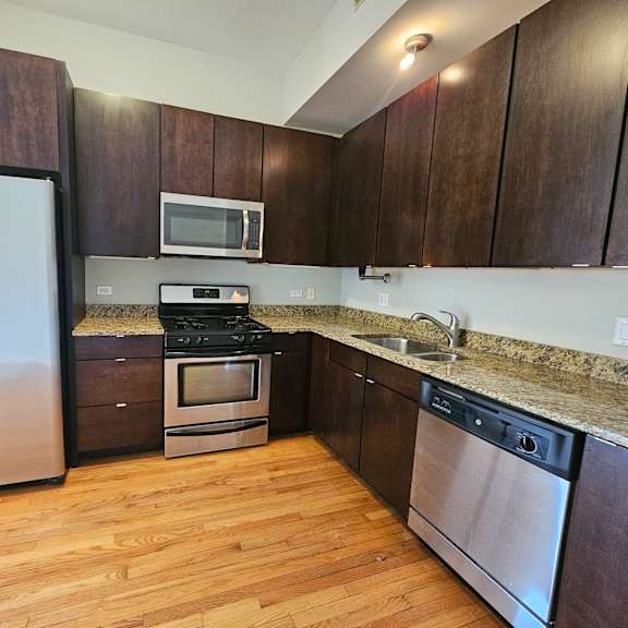 a kitchen with wooden cabinets and stainless steel appliances