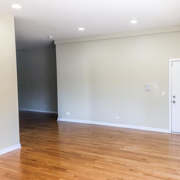 a living room with white walls and wood floors
