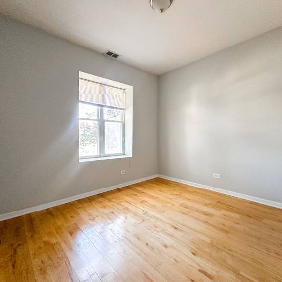 a room with wooden flooring and a window letting in light.