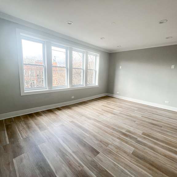 a room with wooden flooring and a window overlooking a cityscape.