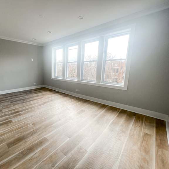 a room with wooden flooring and a window.