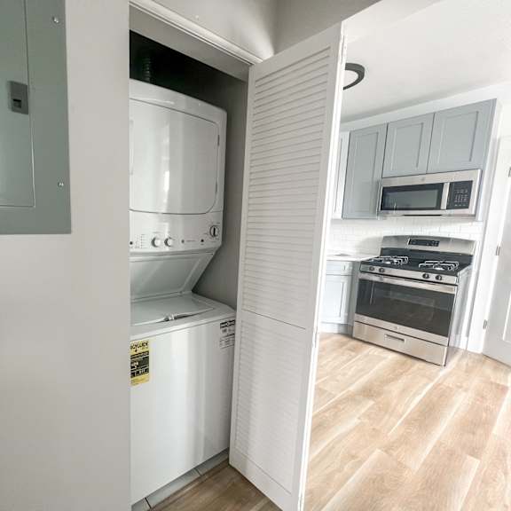 a kitchen with a white fridge, microwave, oven, and stove.