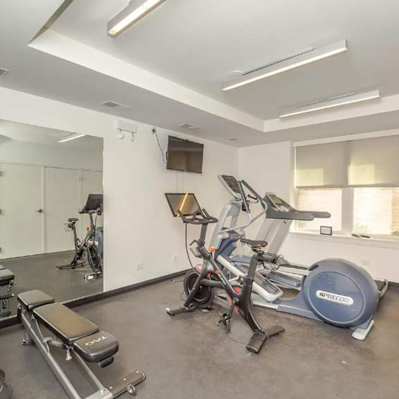 a workout room with cardio equipment and weights in a gym
