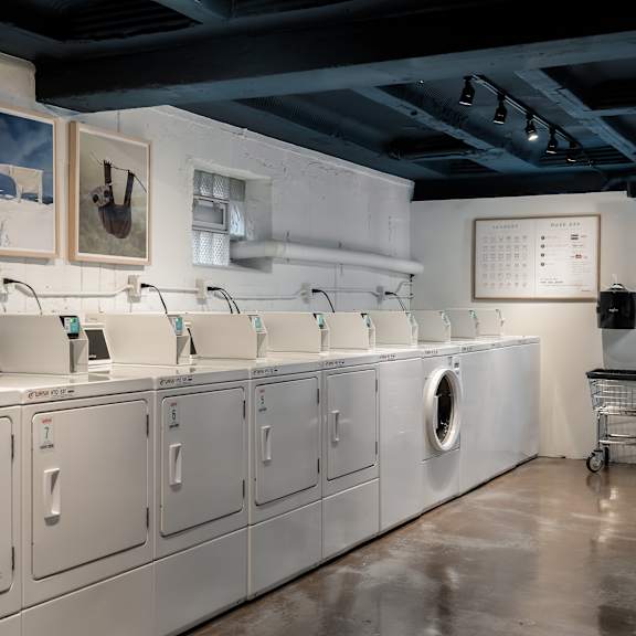 a row of washing machines are lined up in a laundromat.