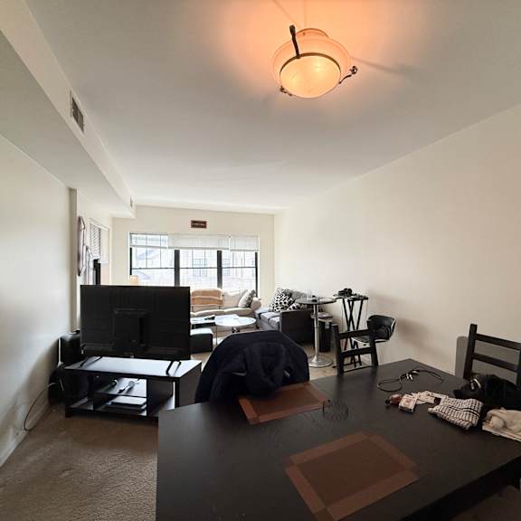 a living room with a black table and chairs.