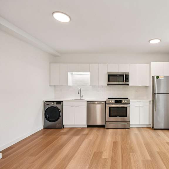 a kitchen with white cabinets and stainless steel appliances.