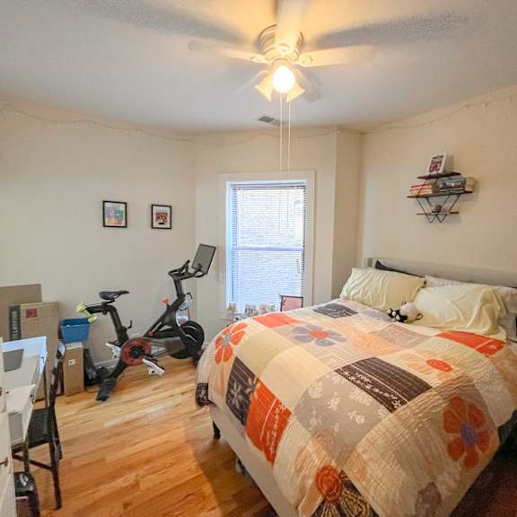 a bedroom with a bed and an exercise bike in the corner