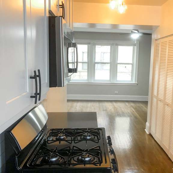 a kitchen with a stove top oven and a window.
