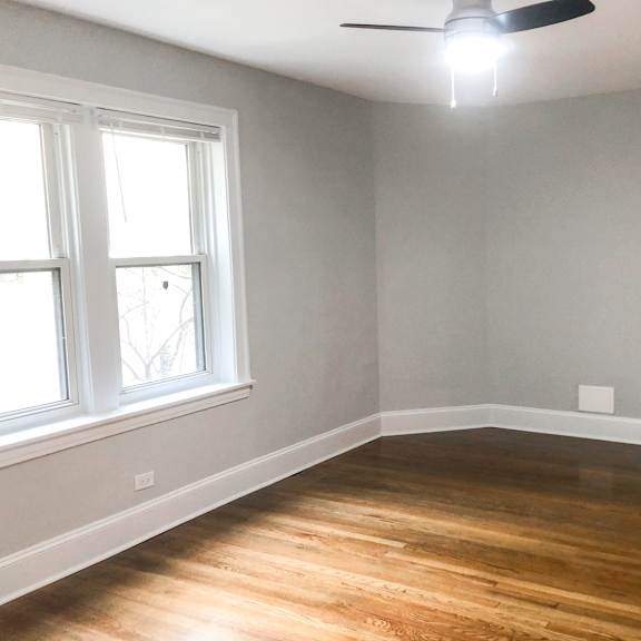 a room with a ceiling fan and a window.