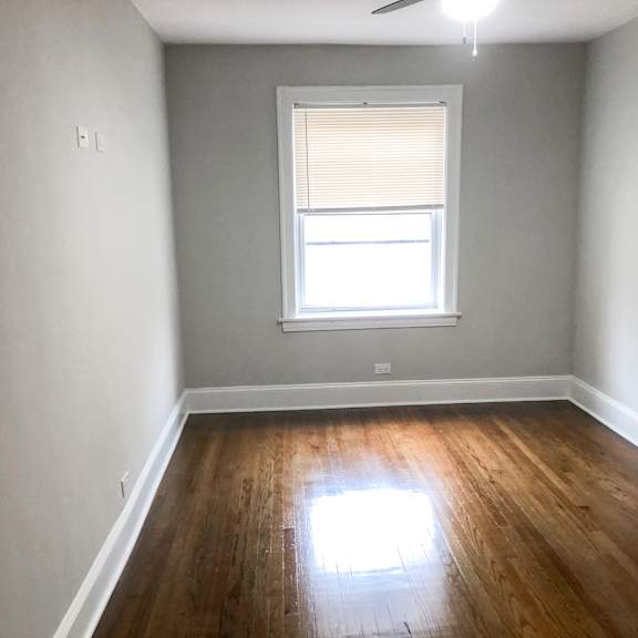 a room with a window and wooden floors.