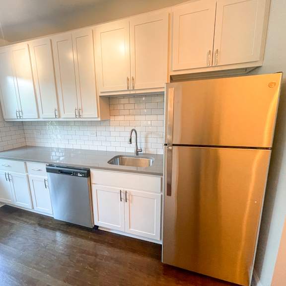 a kitchen with white cabinets and a stainless steel refrigerator.
