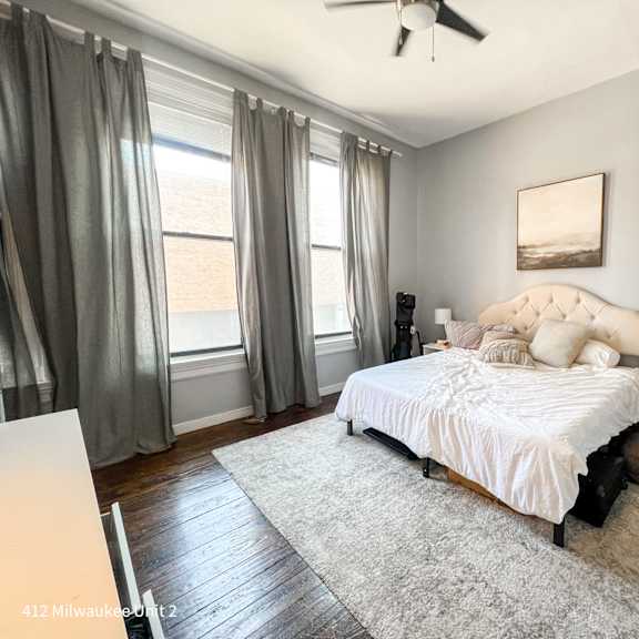 a bedroom with a large bed and a ceiling fan.