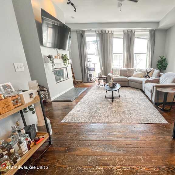a living room with a couch, a chair, a coffee table, and a rug.