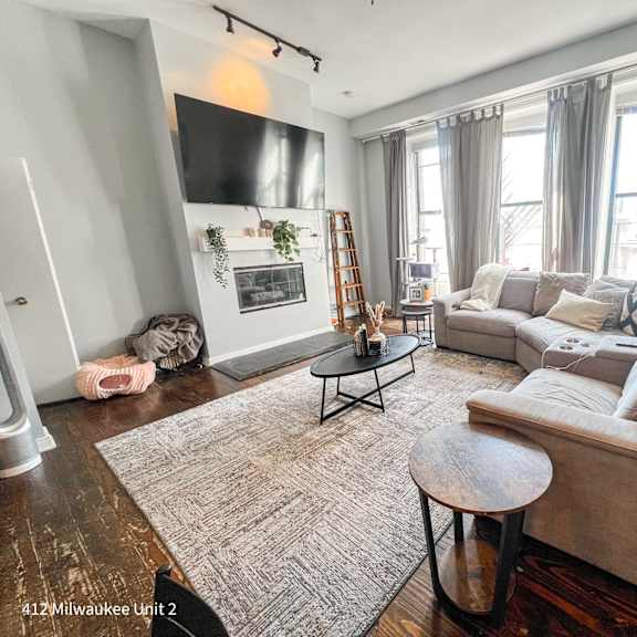 a living room with a couch, coffee table, and fireplace.