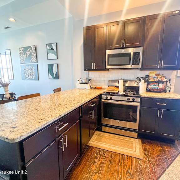a kitchen with black cabinets and a granite countertop.