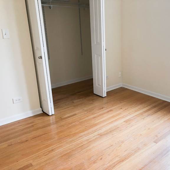 an empty room with wood floors and a closet