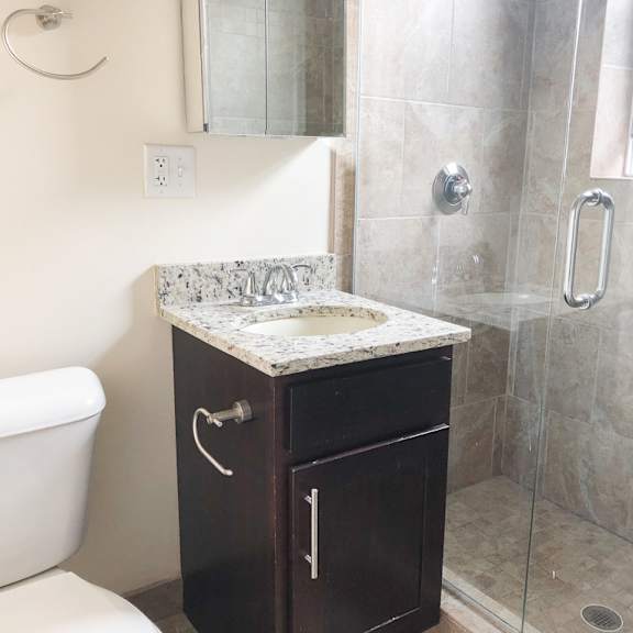 a small bathroom with a shower sink and toilet