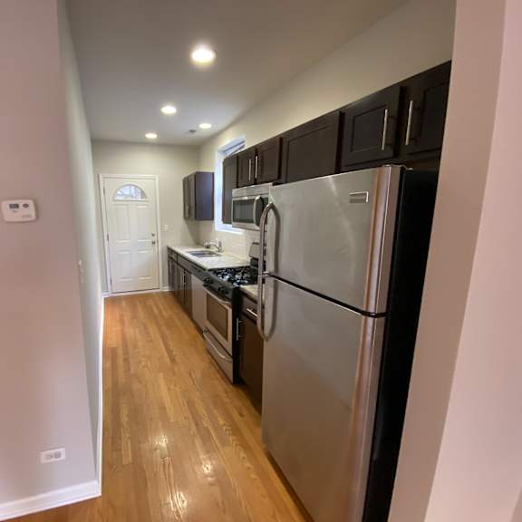 a kitchen with stainless steel appliances and black cabinets