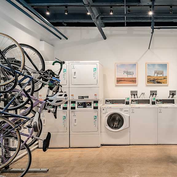 a laundry room with washing machines and bicycles hanging on the wall