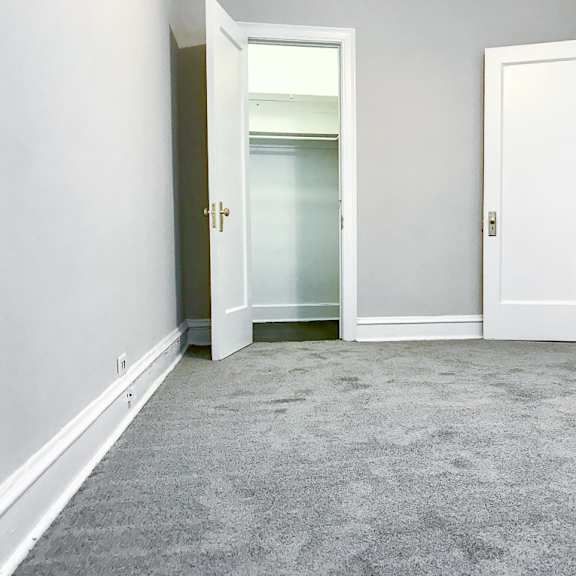 an empty room with white doors and a carpeted floor