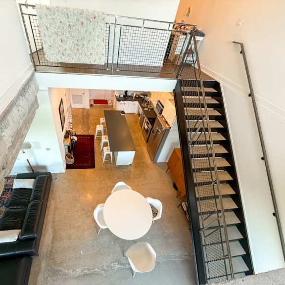 a staircase with a metal railing leads up to a second floor.