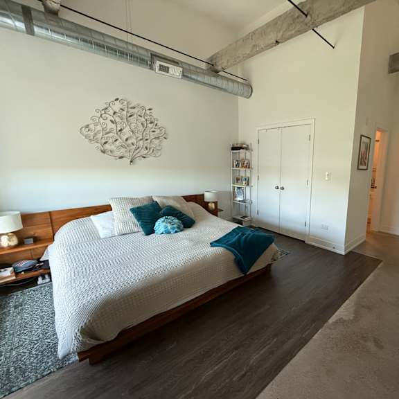a bedroom with a large bed and a wooden floor.