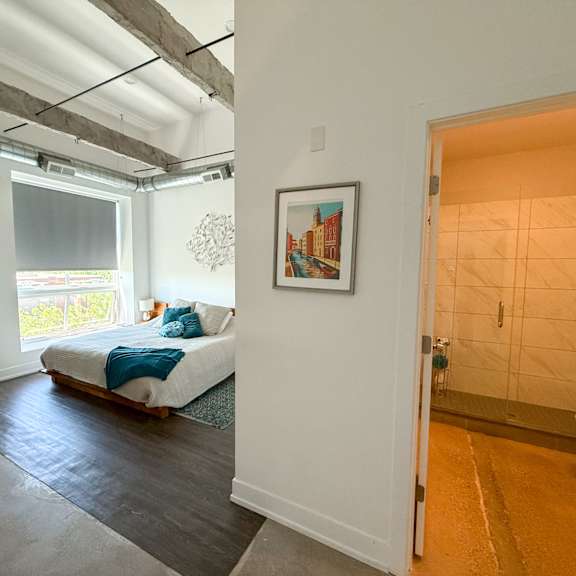 a bedroom with a bed and a painting on the wall.