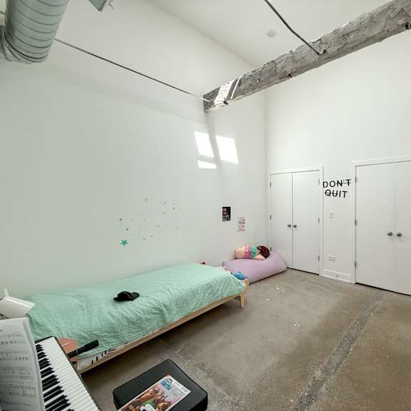a room with a bed, a desk, and a wall with a "don't quit" sign.