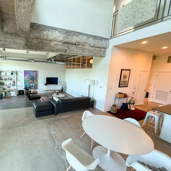 a living room with a black couch and a white chair.