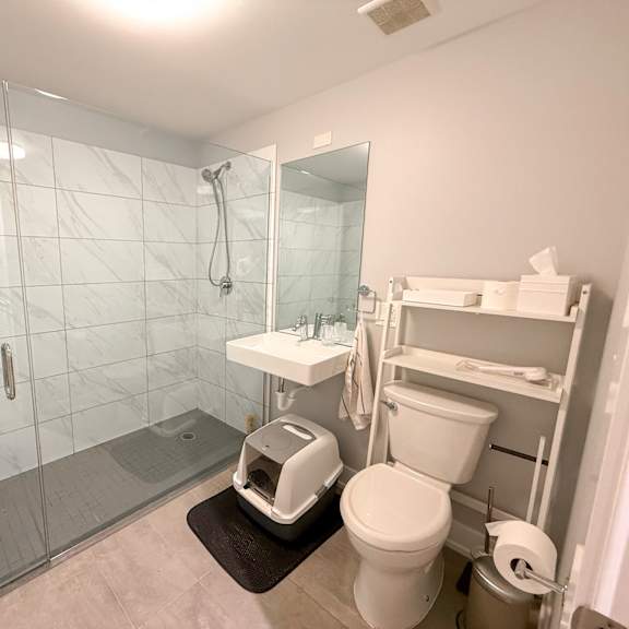 a white toilet is in a bathroom with a glass shower door.