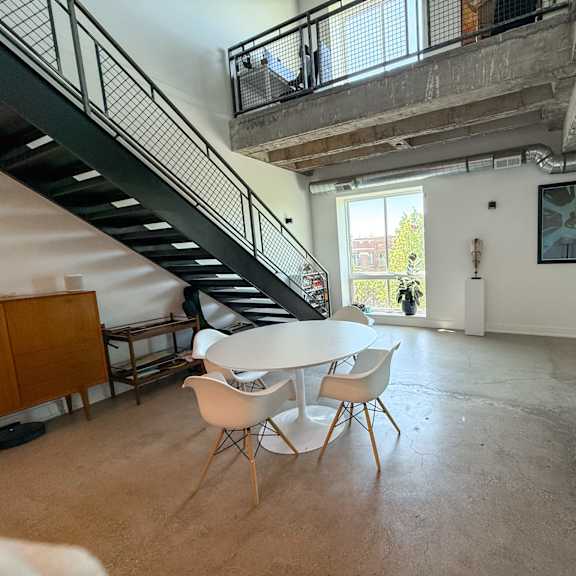 a living room with a staircase and a couch.