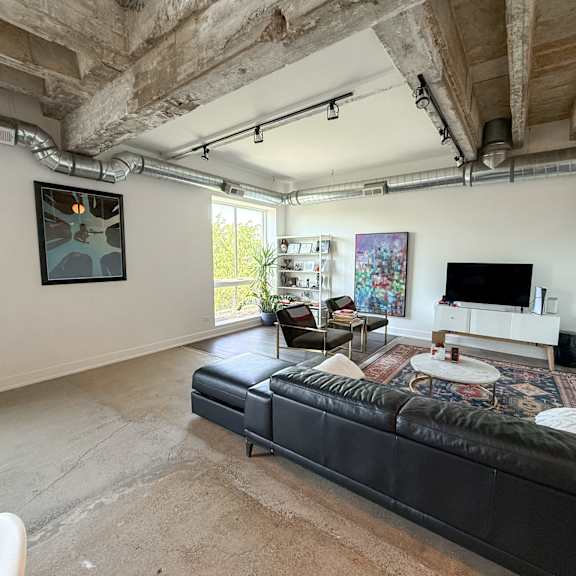 a living room with a black couch and a television.