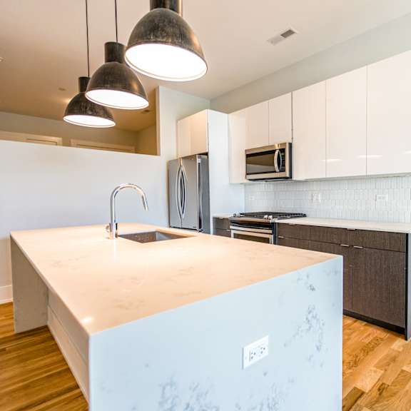 a kitchen with white cabinets and a large counter top
