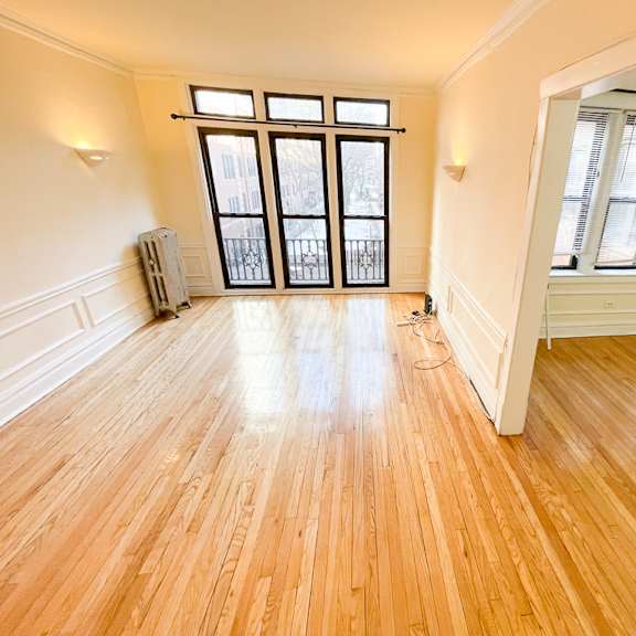 a room with wooden floors and a large window.