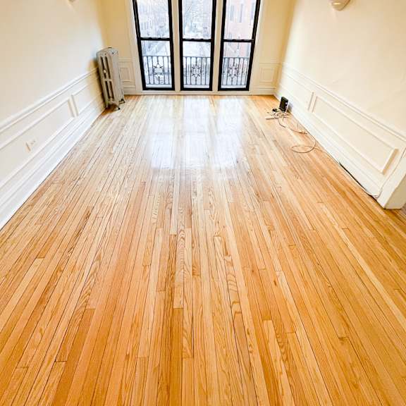 a room with wooden floors and a large window.