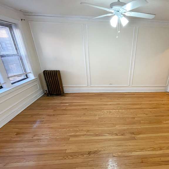 a room with wooden flooring and a ceiling fan.