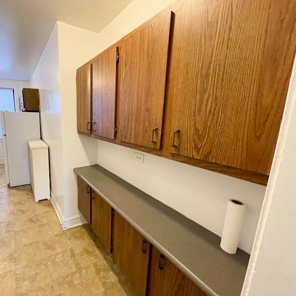 a kitchen with wooden cabinets and a white fridge.