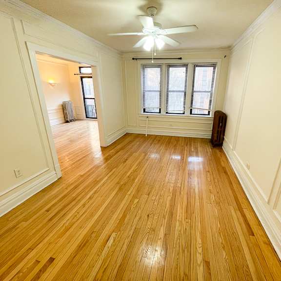 a room with wooden floors and a ceiling fan.