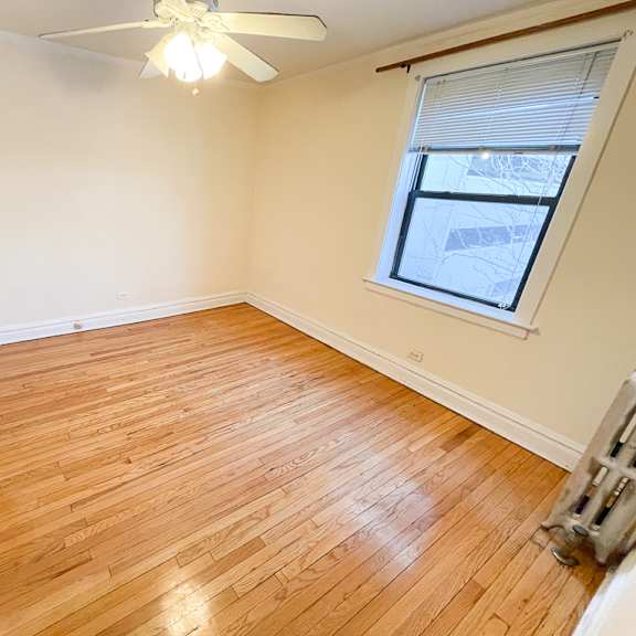 a room with wooden flooring and a ceiling fan.