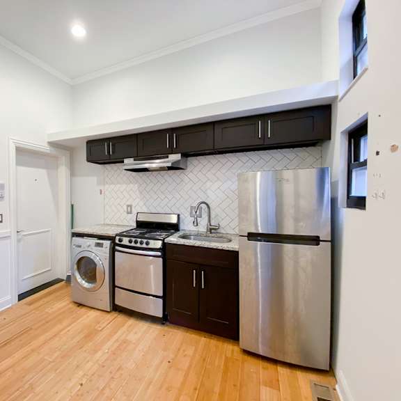 a kitchen with wooden floors and stainless steel appliances.